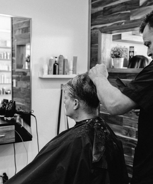 A hairdresser skillfully cuts a client's hair in a contemporary salon environment.
